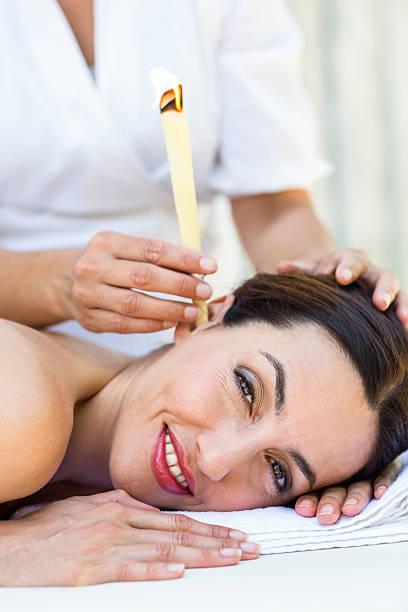 istock Relaxed brunette getting an ear candling treatment 487463082