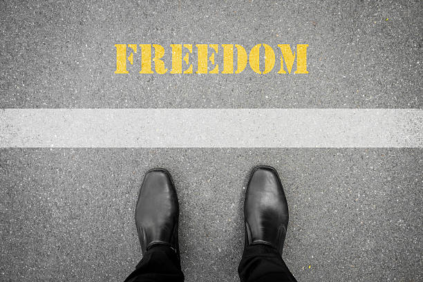 istock Black shoes at the white line - freedom 487463208