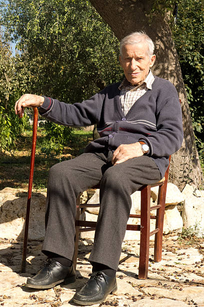 Old man sitting outdoors. Old man sitting outdoors in garden home,under hot sun of autumn,in Puglia land. over 100 stock pictures, royalty-free photos & images