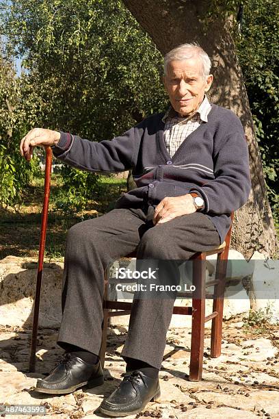 Foto de Velho Homem Sentado Ao Ar Livre e mais fotos de stock de Mais de 100 Anos - Mais de 100 Anos, Homens, Oliveira