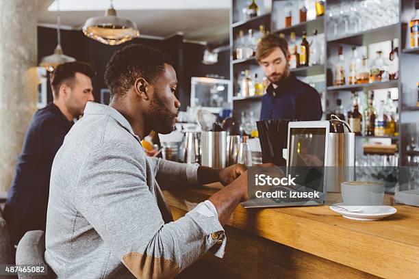 Afro American Man Using Laptop In A Pub Stock Photo - Download Image Now - Incidental People, Laptop, 2015