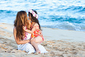 Beautiful mother and daughter wearing Lei on Hawaiian beach