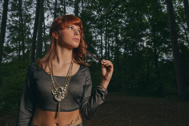 Young Gypsy girl in the woods looking off.