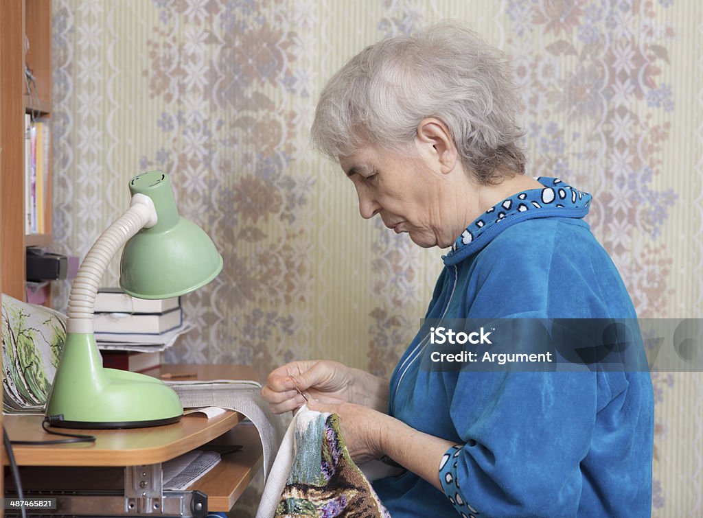 favorite hobby elderly woman doing embroidery at your desk at home Active Seniors Stock Photo