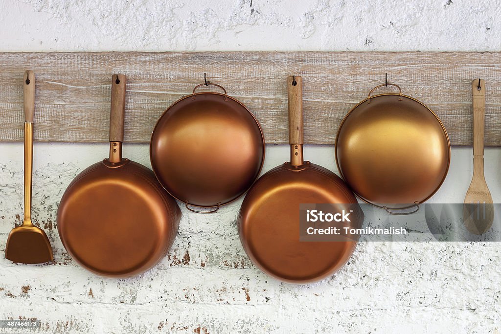 Copper  kitchen utensil Copper  kitchen utensil on the white painted brick wall Copper Stock Photo