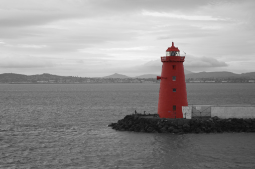 Black and White shot of Poolbeg Lighthouse at Dublin Port. The lighthouse is coloured red which contrasts with the black and white.