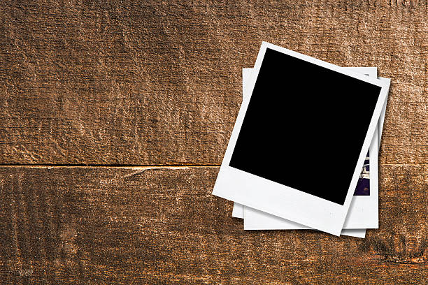 istock Blank photo frames on old wooden background. 487468721