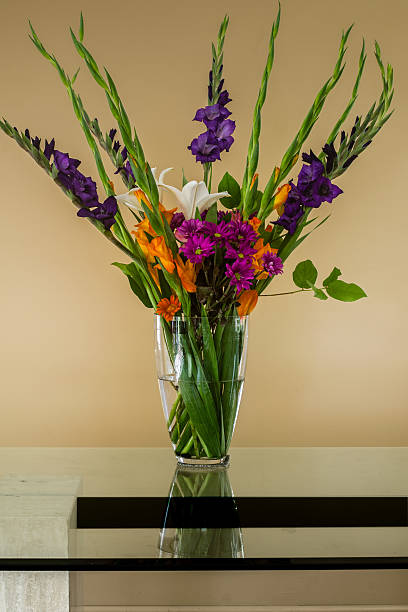 istock flowers in a glass vase on a glass table 487468880