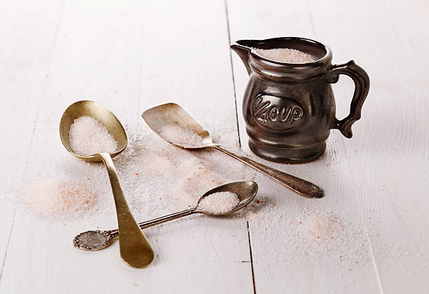 istock Himalayan pink salt in a measuring cup on wooden background 487469817