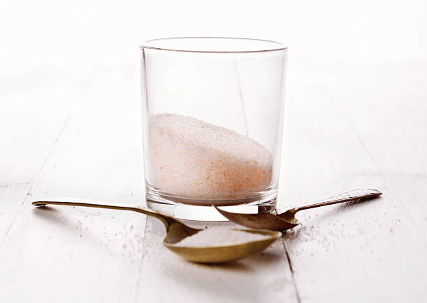 Himalayan pink salt in a glass on wooden background