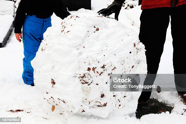 Rolling A Snowball Stock Photo - Download Image Now - Adult, Blizzard, Child