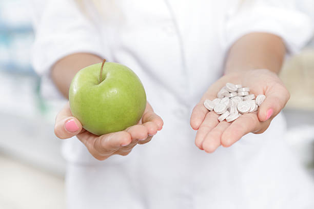 istock Close up of a pharmacist holding an apple 487471134
