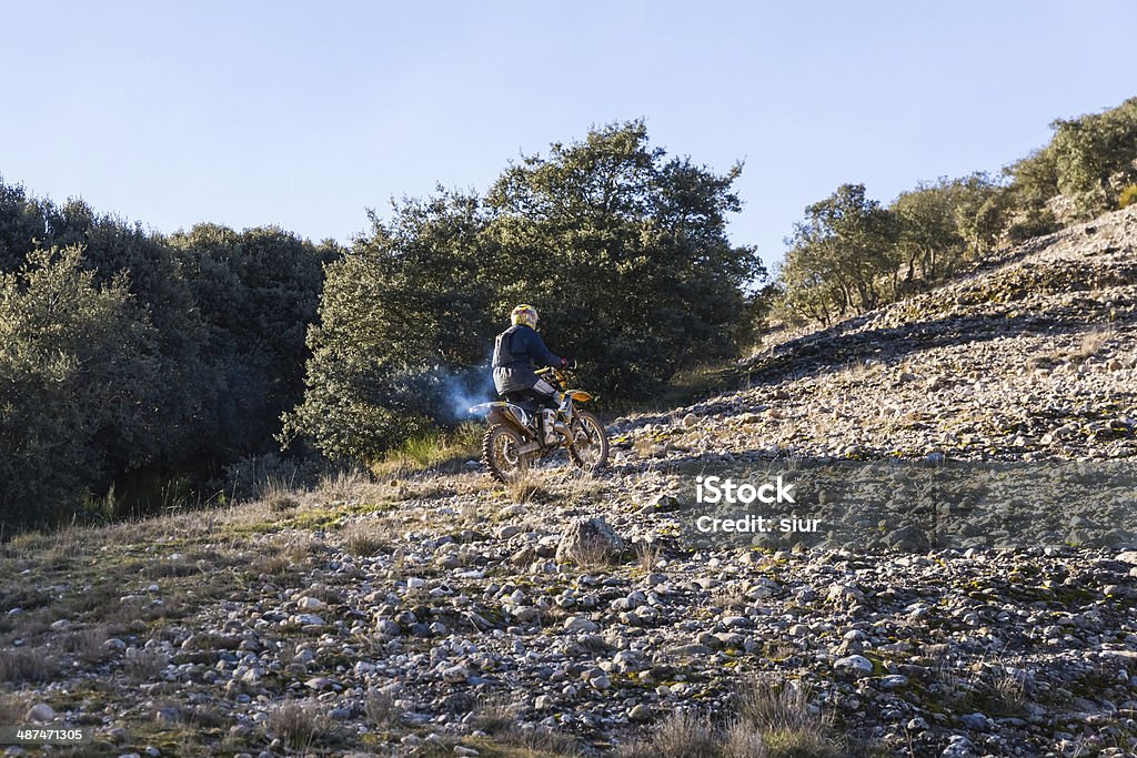 Motocross Motorcyclist rising motocross bike with a slope of stones - Motorcyclist climbing with motocross bike a slope of stones Adult Stock Photo