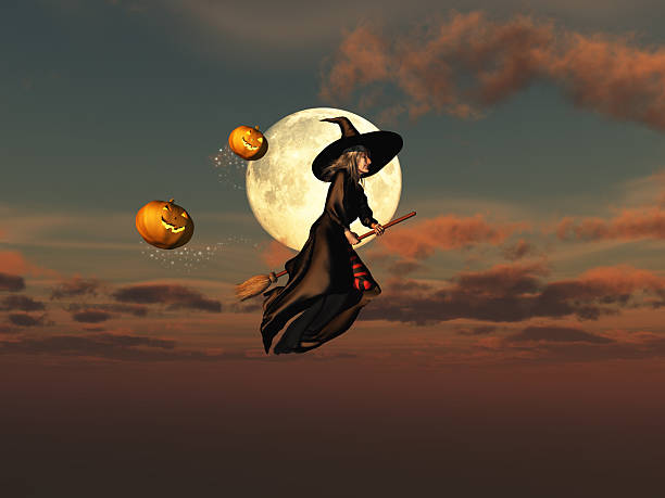 Witch on a broomstick and jack-o'-lanterns stock photo