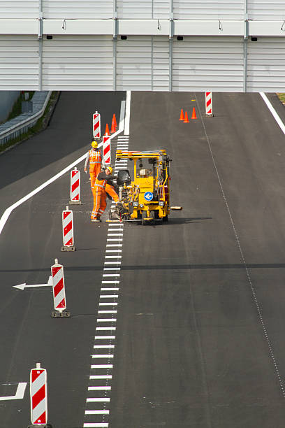 roadworkers travaillant sur la nouvelle autoroute - editorial safety in a row industry photos et images de collection