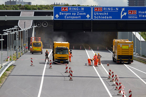 roadworkers travaillant sur new road. - editorial safety in a row industry photos et images de collection