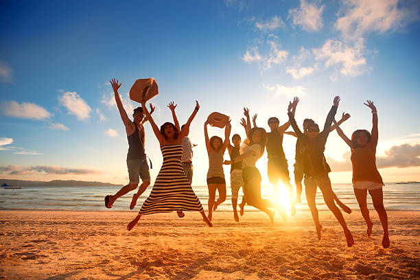 istock happy young people jumping at the beach on beautiful sunset 487480184