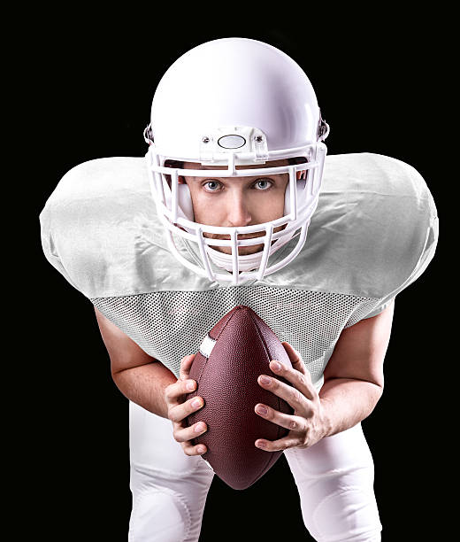 istock Football Player on white uniform isolated on black background 487480192