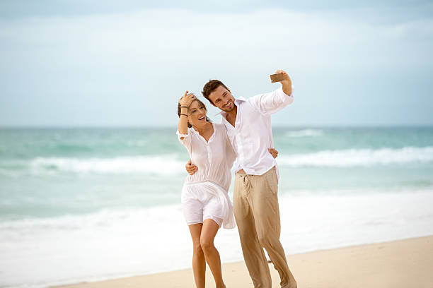 istock couple making self photo on the beach 487480256