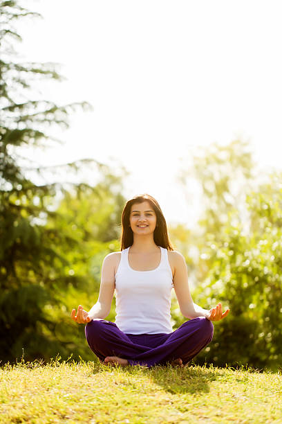 istock Young Woman Meditating in Field 487485093