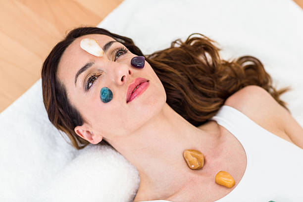 istock Relaxed brunette lying on mat with stones 487485308