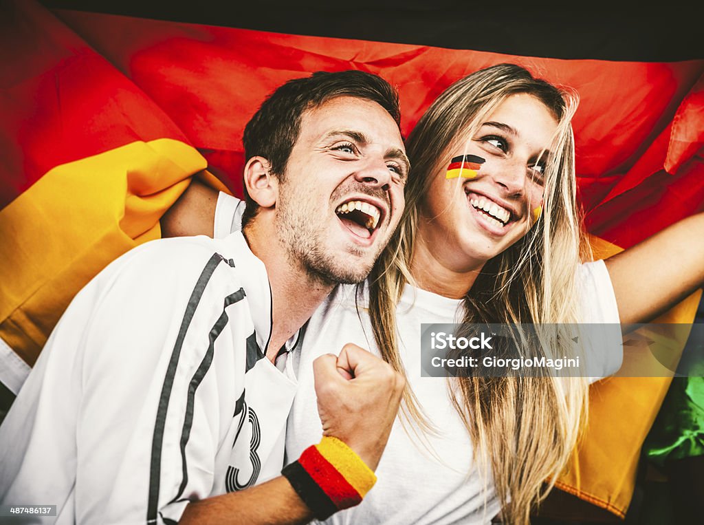 Saksalainen nuoripari tukemassa joukkuetta - Rojaltivapaa avainsanalla Football - Sport ja tyyppiä Kuvapankin valokuva