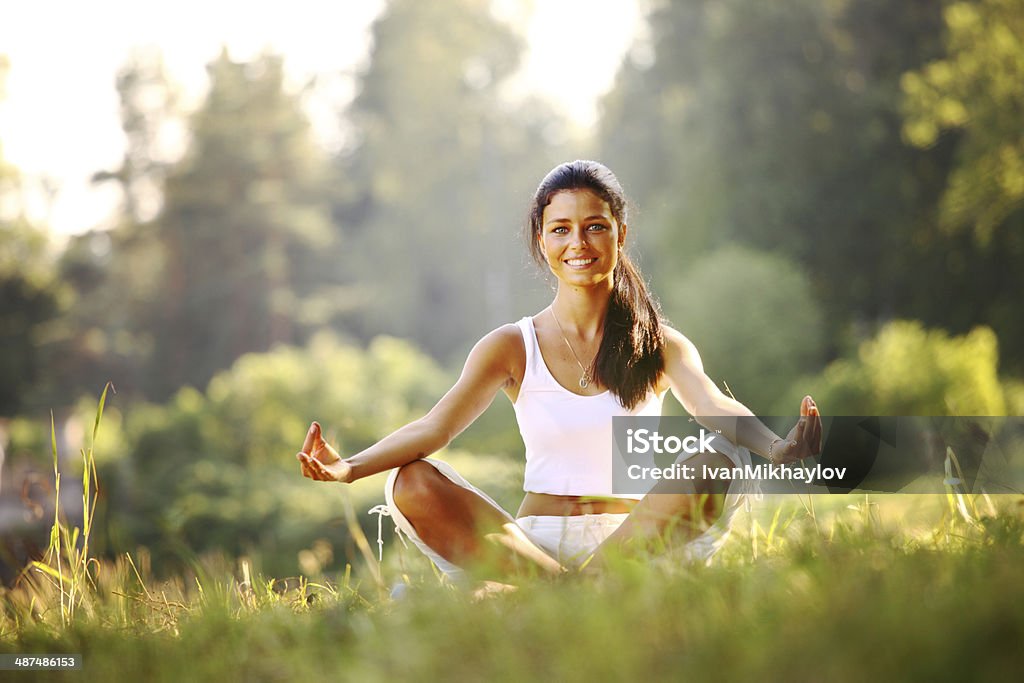 lotus yoga yoga woman on green grass in lotus pose Adult Stock Photo