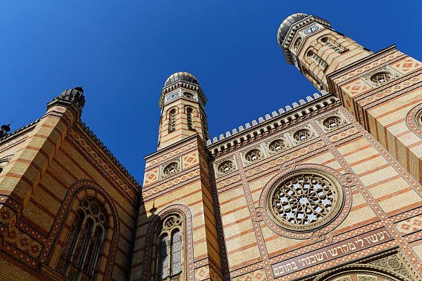 Autumn Cityscape of Great Synagogue Dohany Street Budapest on the 7th Evening of Sukkot as Jewish Holiday, Deak Ferenc Square Neighborhood, in Erzsébetváros, 7th District of Downtown Budapest, Hungary, Europe on a Sunny Sunday Afternoon in September 2021 - The Dohány Street Synagogue is known as the largest synagogue in all of Europe. The complex, which showcases the ancient historical Jewish traditional motif and symbol system, consists of the Great Synagogue, the Church of the Heroes, the Cemetery, the Monument and the Jewish Museum. The area, which enjoys cultural protection, has survived the historical vicissitudes of the 20th century, and the Hungarian Jewish people in Hungary preserve the architectural monuments in their beautiful condition.