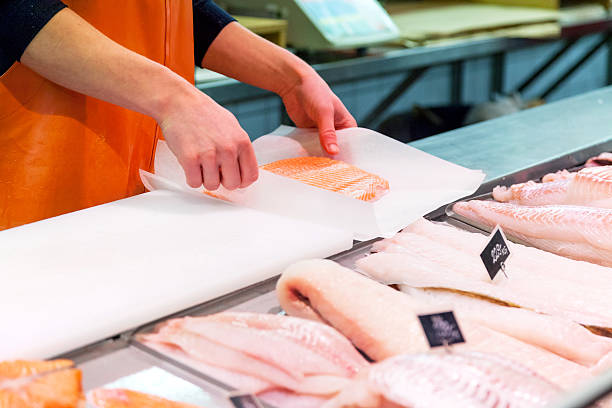 Fish market Unrecognizable man packing fresh salmon fillet, copy space fish market photos stock pictures, royalty-free photos & images
