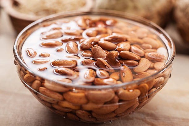 Soaked Bean in glass bowl Soaked been in glass bowl on chopping board; close up; drenched stock pictures, royalty-free photos & images