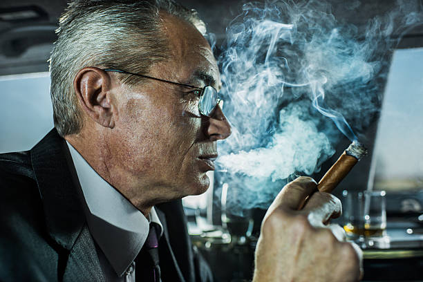 istock Mature businessman smoking a cigar. 487487483