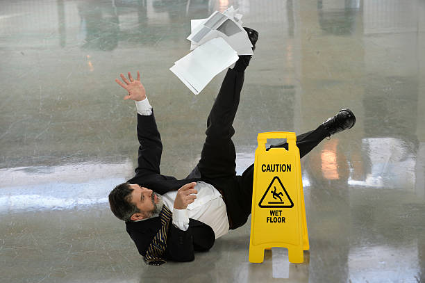 businessman falling on wet floor - val stockfoto's en -beelden