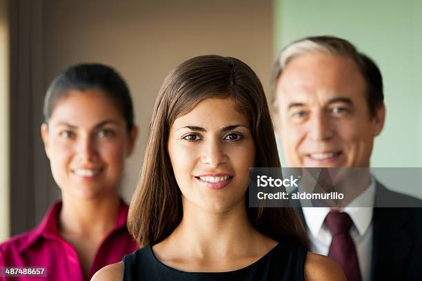 Beautiful Latin Business Woman With Team Behind Stock Photo - Download Image Now - 30-39 Years, 60-69 Years, Active Seniors