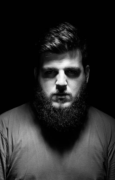 istock mysterious male portrait. Low key, black background. 487489120