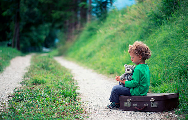 Child Traveling Alone with his Bear Toy and Luggage