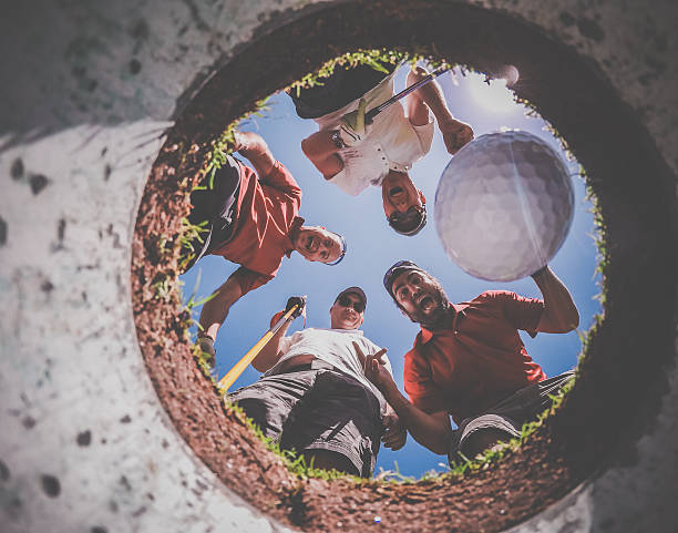 Point Of View Golf Players and Ball From Inside Hole