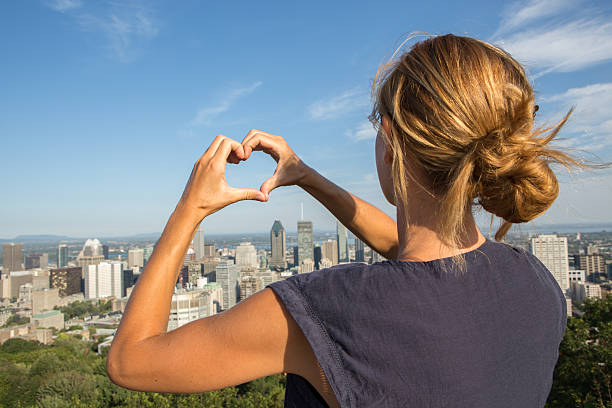 istock Young cheerful woman in Montreal-Canada making heart shape with hands 487489678