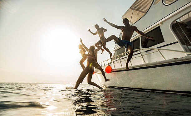 istock Young happy friends jumping from boat at sunset. 487491794