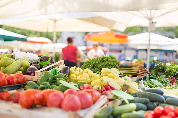 Farmers' food market stall with variety of organic vegetable. Farmers' food market stall with variety of organic vegetable. Vendor serving and chating with customers. freshness stock pictures, royalty-free photos & images