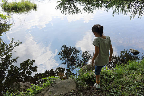 istock child who looks into a lake 487494208