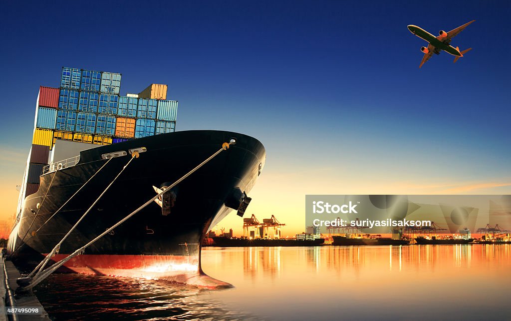 container ship at port and cargo plane container ship at port and cargo plane in logistic industry flying above Freight Transportation Stock Photo