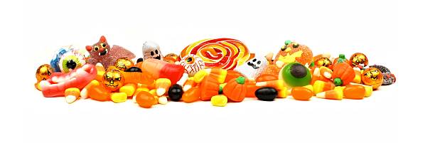 Pile of Halloween candy over white Long pile of colorful Halloween candy and sweets over a white background eye candy stock pictures, royalty-free photos & images