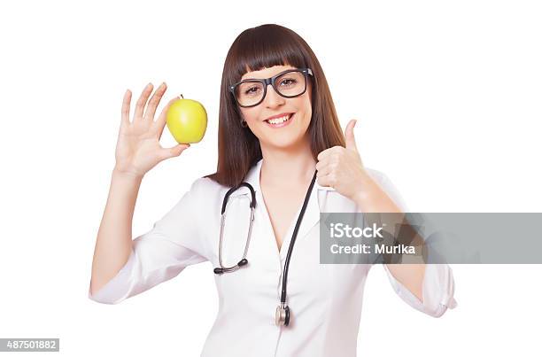 Woman In A White Lab Coat With Apple Stock Photo - Download Image Now - 2015, Adult, Analyzing