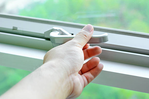 istock Hand holding glass window latch lever 487502544