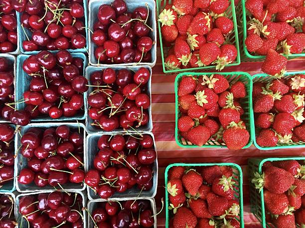 Cherries and strawberries in baskets for sale at farmer's market