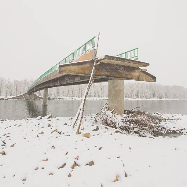 Square landscape of an angled view of a flood damaged bridge in winter.