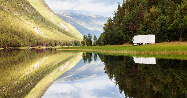 istock Truck in landscape  reflected  in the clear waters at sunset. 487505986