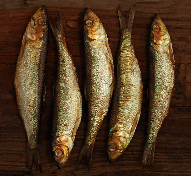 istock herring sprat fish smoked on  wooden table background 487506504