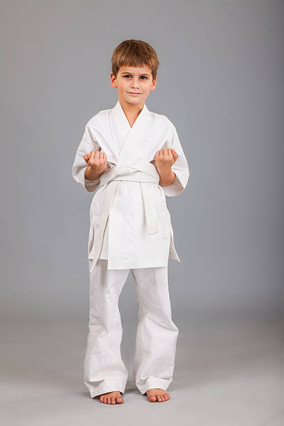 istock Karate boy in white kimono fighting 487508029