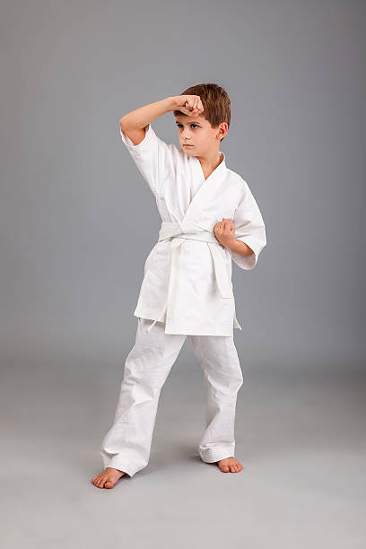 istock Karate boy in white kimono fighting 487508271